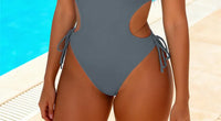 Gros plan sur le bas du maillot une pièce à découpes décolleté plongeant gris ardoise