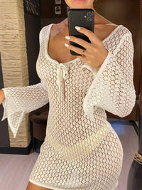 Tunique de plage crochet ajourée blanc col en V portée de face par une femme, lien noué au décolleté dans une pièce lumineuse