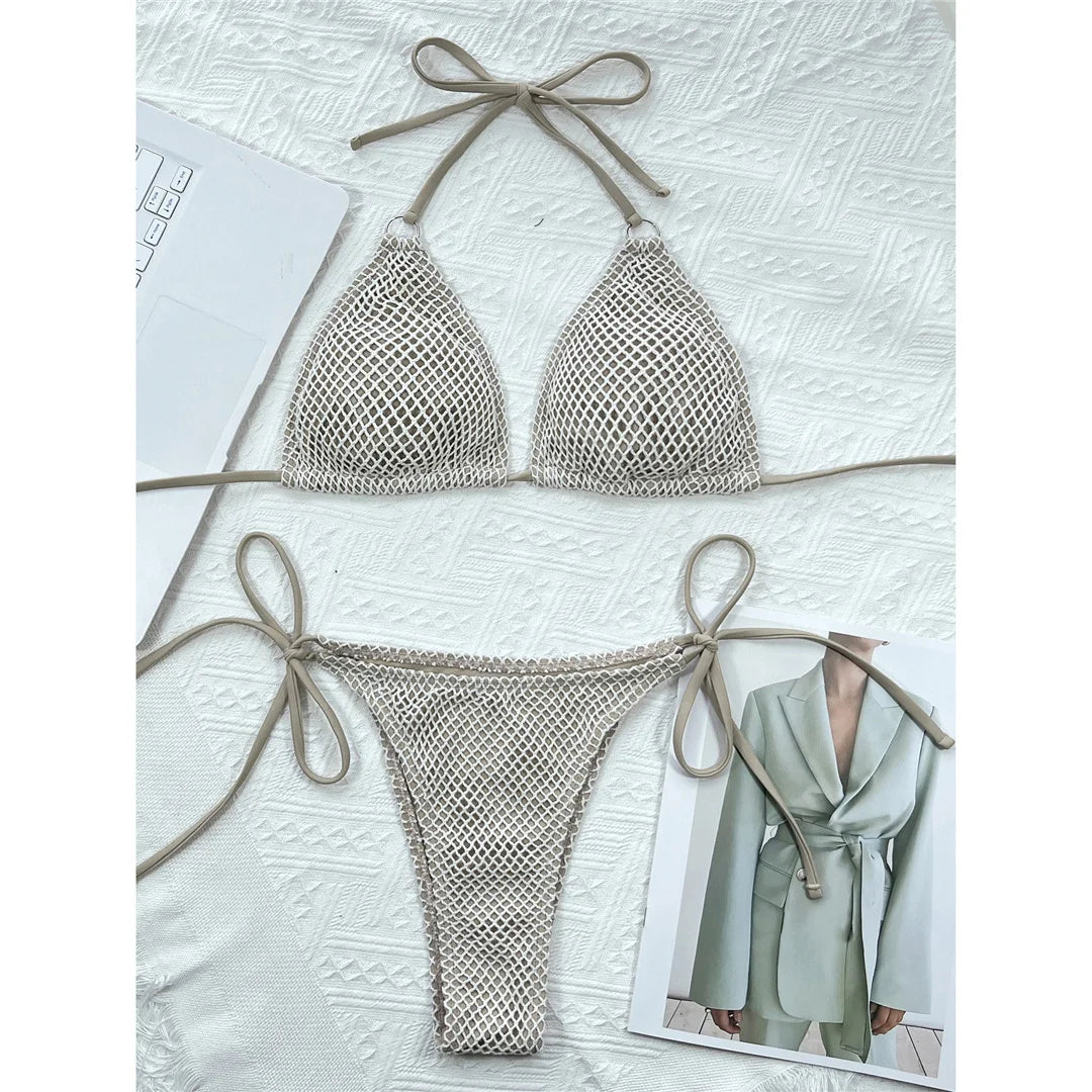 Bikini brésilien tour de cou à effet résille vert kaki à plat sur une veste blanche, à côté d'un magazine