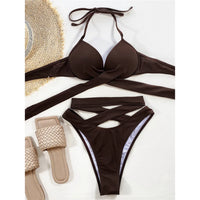 Bikini à armatures taille haute croisé effet bandage marron posé à plat avec chapeau de paille et sandales beiges