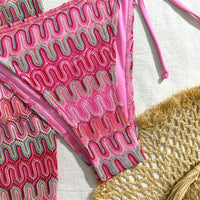 Gros plan sur le bas rose vif au crochet ondulé et ses liserés unis, la jupe en arrière-plan