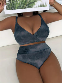 Gros plan sur le haut noir délavé côtelé à décolleté croisé, porté allongé sur un canapé blanc, bas taille haute