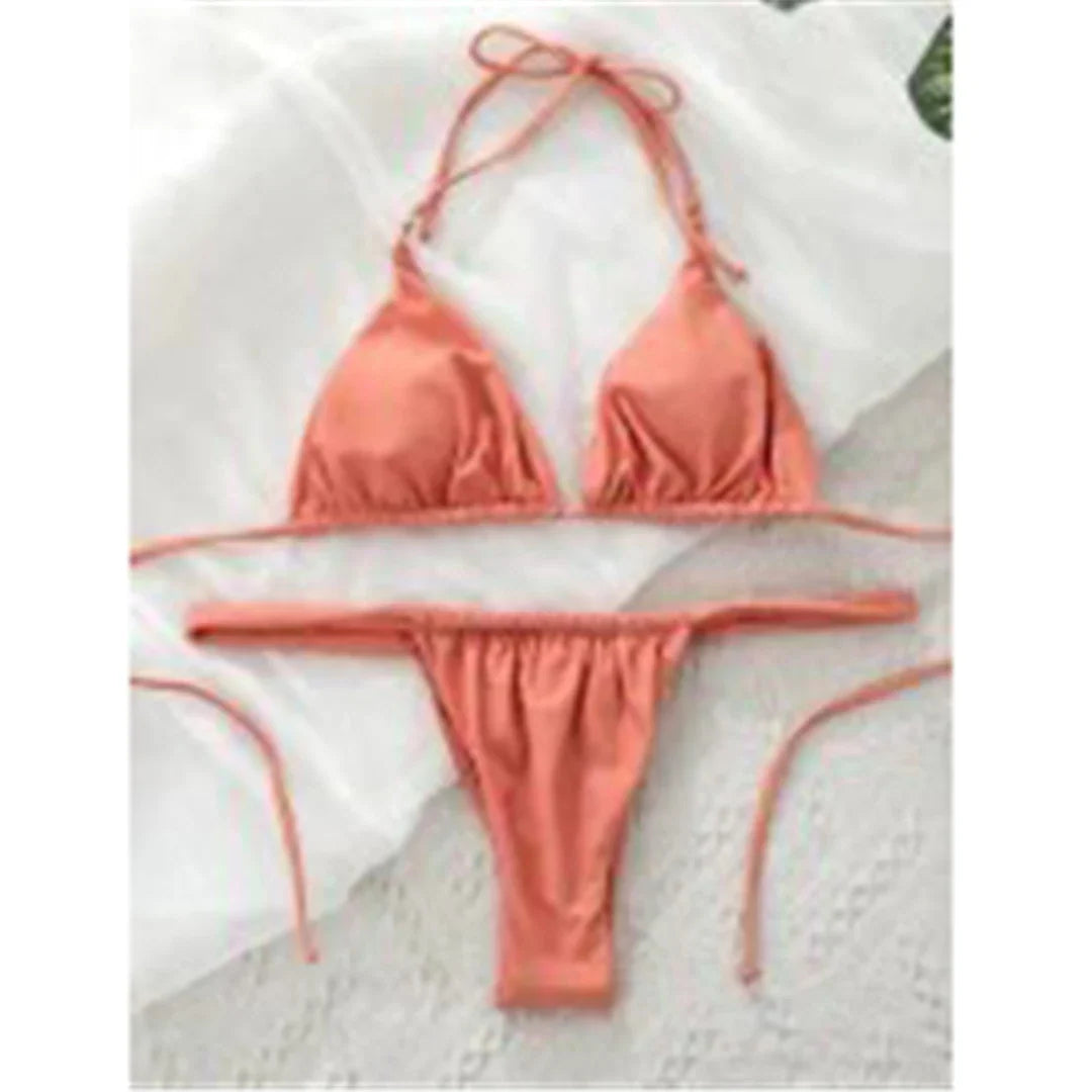 Bikini string triangle froncé rose nude posé à plat sur un tissu clair, liens longs et bas taille basse