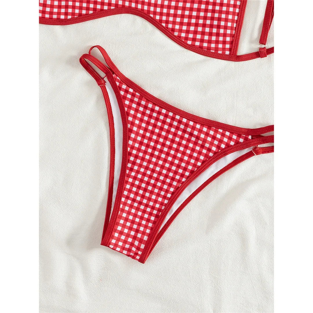 Gros plan sur le bas taille basse à carreaux rouge, bandes latérales doubles bordées de rouge sur tissu blanc