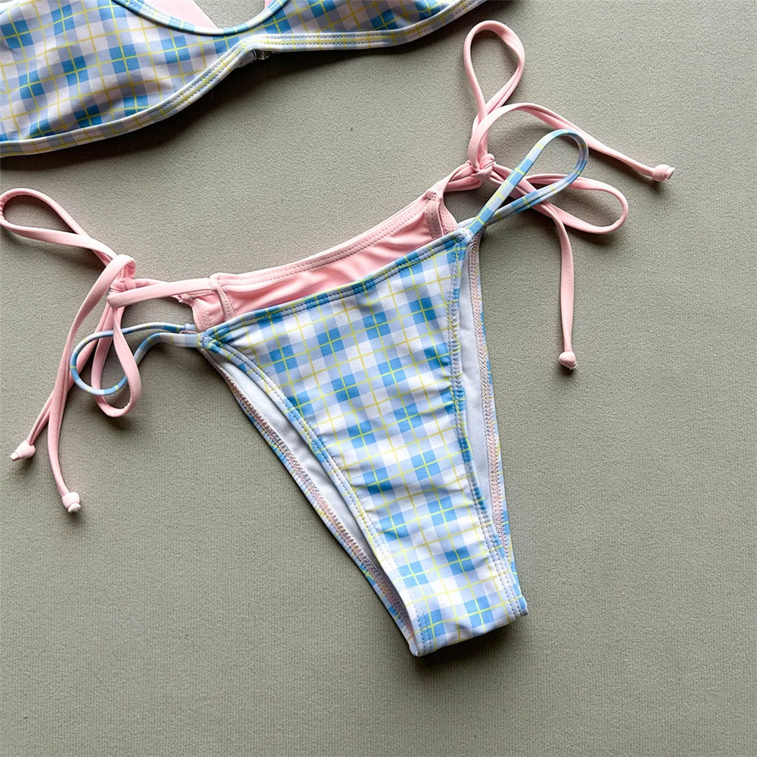 Gros plan sur le bas à carreaux bleu ciel, liens roses noués sur les côtés et doublure rose sur la ceinture