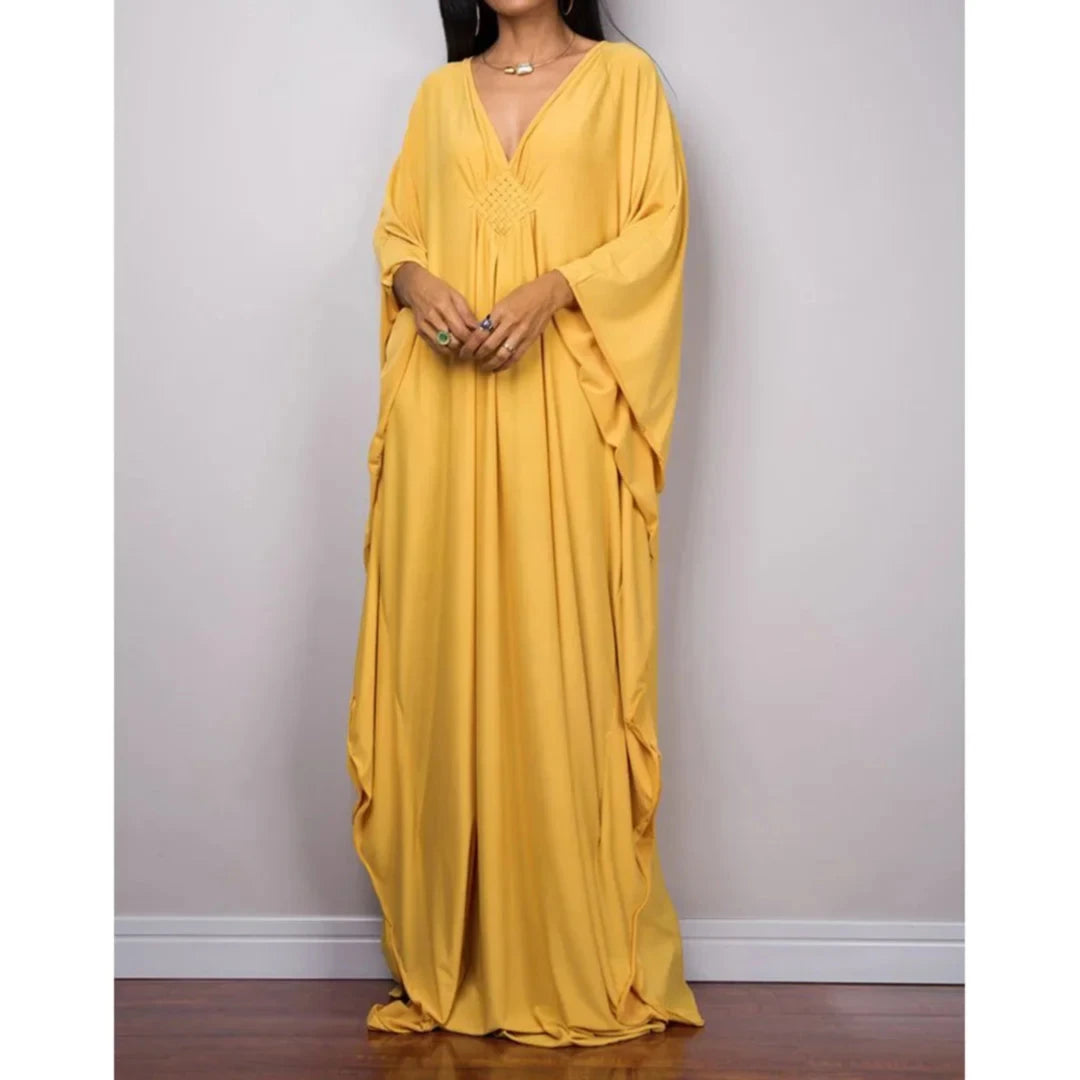 Robe de plage longue kaftan manches chauve-souris jaune portée de face, bagues aux doigts et mains posées sur la taille