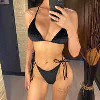 Bikini tour de cou échancré noir à motif gaufré porté de face, une main sur le bas, selfie devant un miroir