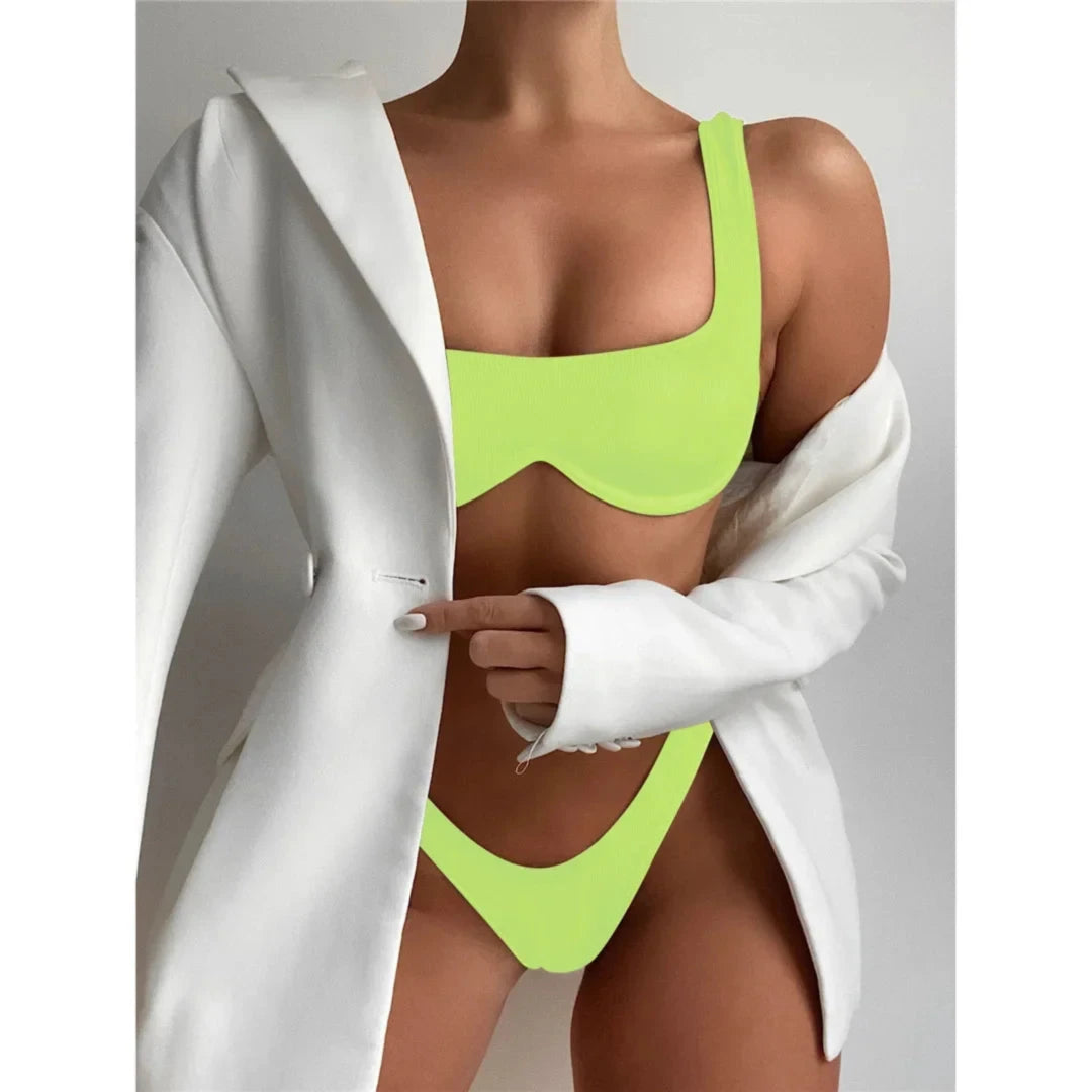 Bikini à armatures brésilien détail en V vert fluo porté de face sous un blazer blanc, bonnets à armatures