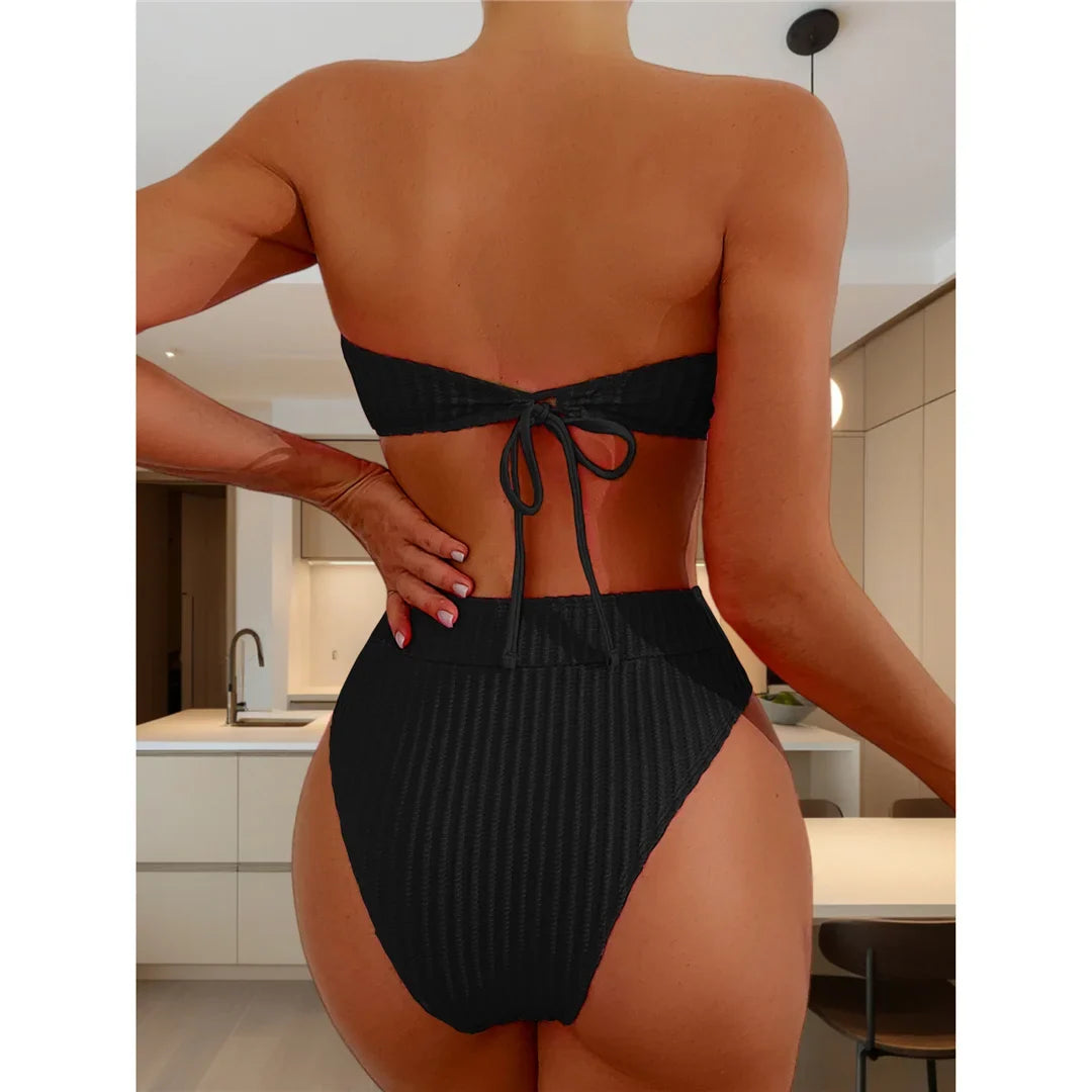 Bikini bandeau taille haute texturé noir vu de dos sur une femme, lien noué au centre du dos et bas taille haute côtelé