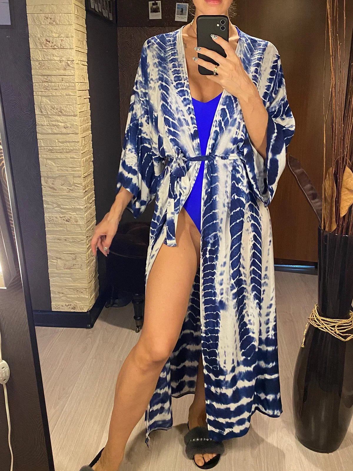Tunique de plage imprimée manches longues à ceinture bleu foncé portée de face devant un miroir, maillot bleu dessous