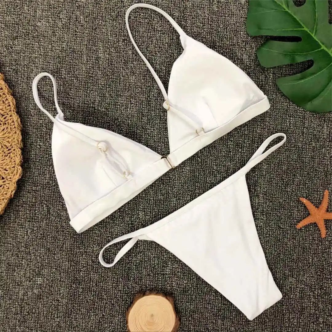 Bikini brésilien rembourré à taille basse blanc posé à plat, anneau central du triangle et feuille verte