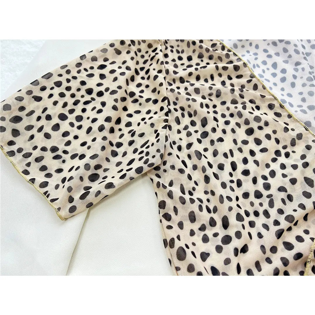 Gros plan sur le tissu imprimé léopard du maillot trois pièces taille haute, taches noires sur fond beige