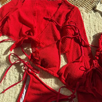 Gros plan sur les lacets rouges du bikini triangle et le haut en maille posé sur un tapis clair