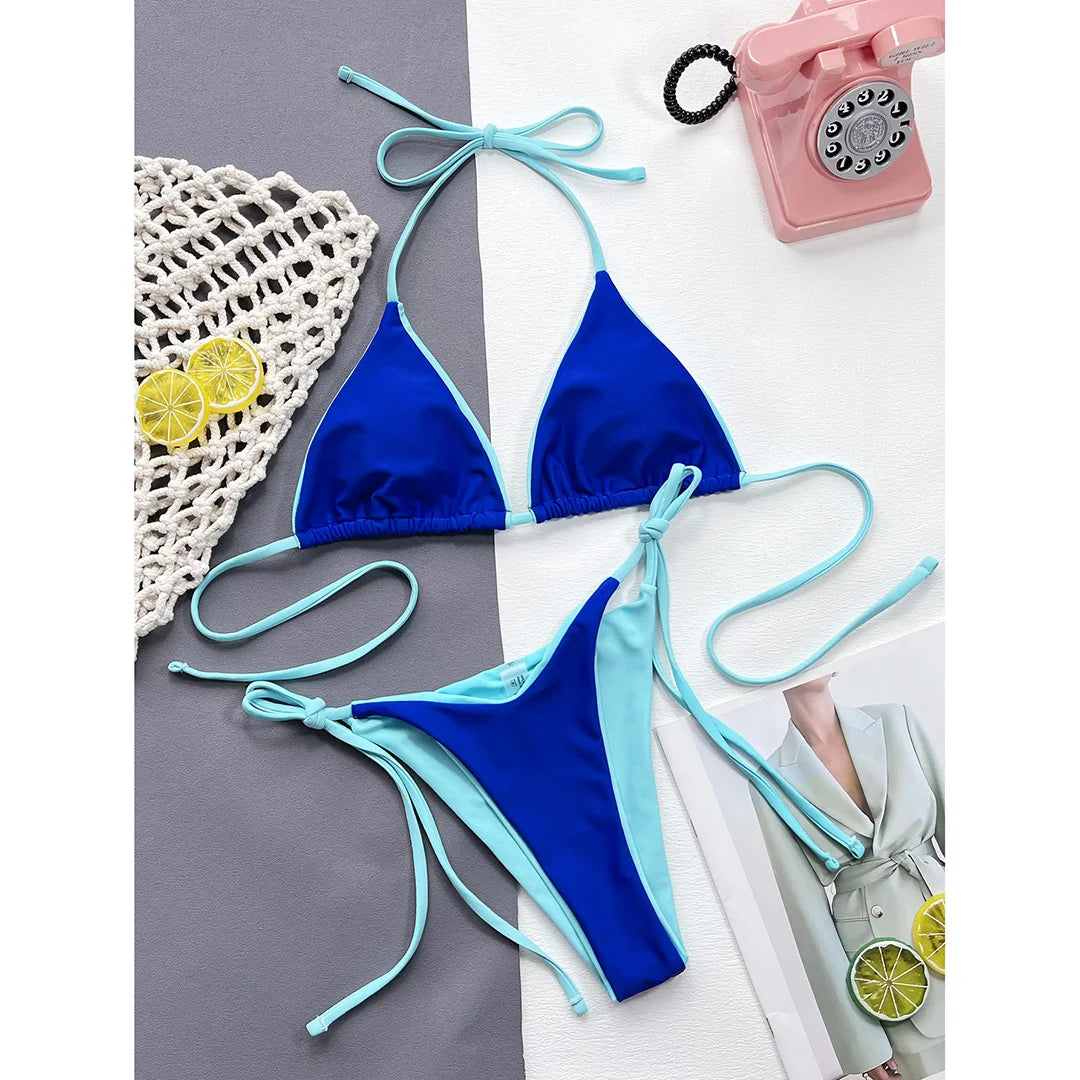 Bikini brésilien tour de cou sans armatures bleu roi posé à plat à côté d'un téléphone rose et de citrons