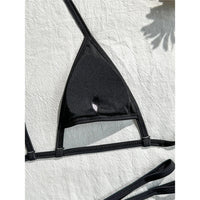 Gros plan sur l'intérieur uni du triangle noir d'un bikini string micro, petite ouverture au centre