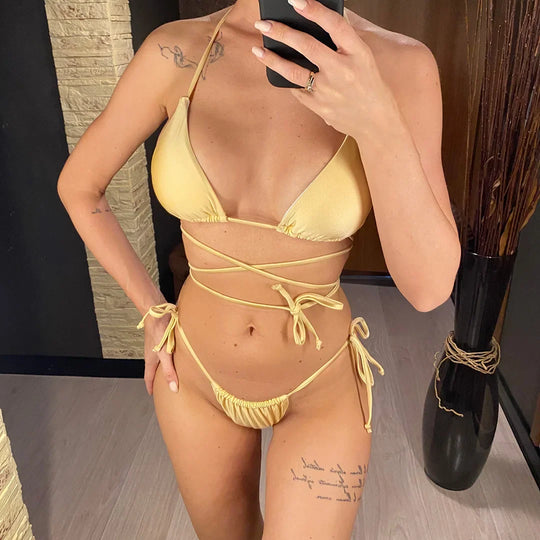 Bikini brésilien croisé rembourré champagne porté de face par une femme qui se photographie dans un miroir, lacets noués