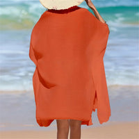 Chemise de plage longue à manches courtes en maille orange vue de dos avec chapeau de paille sur la tête, mer en arrière-plan