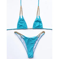 Bikini tour de cou à chaîne métallique bleu ciel posé à plat sur fond blanc, bretelles fines et chaînes dorées