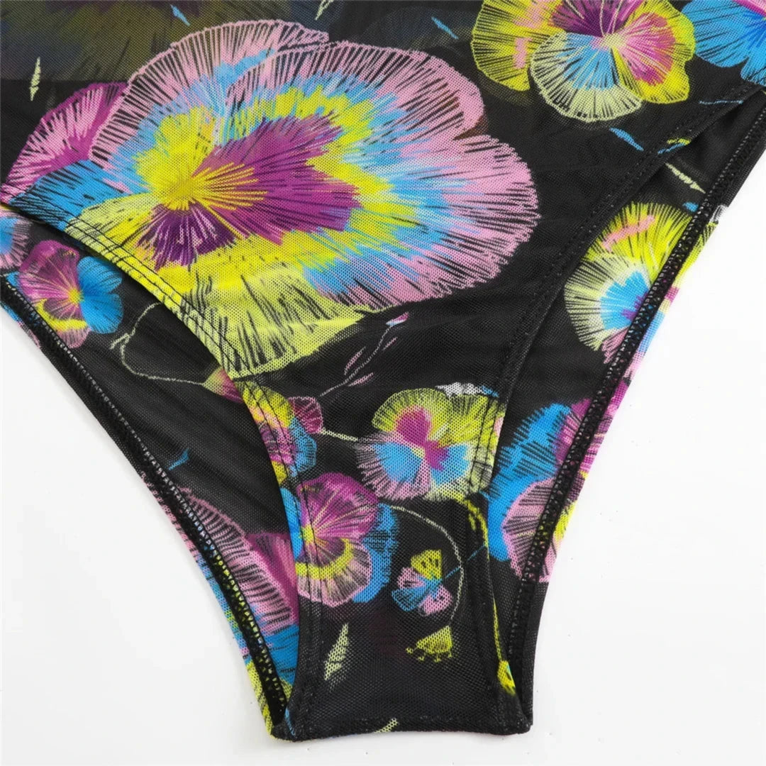 Gros plan sur la culotte du body imprimé fleuri noir, taille haute et fleurs multicolores au tissu transparent