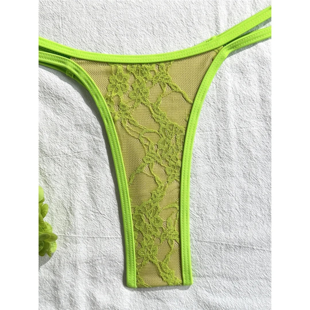 Gros plan sur le bas en dentelle vert fluo du bikini string micro, bretelles doubles sur les hanches