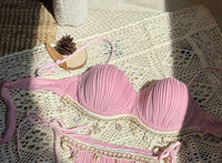 Gros plan sur le haut du bikini balconnet côtelé à armatures et coquillages rose