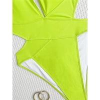 Gros plan sur la découpe latérale du maillot une pièce vert fluo, doublure blanche et deux anneaux dorés