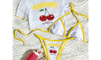 Détail de la matière et des finitions du maillot trois pièces crop top cerises blanc bordé jaune