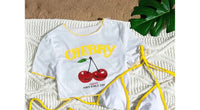 Gros plan sur le haut du maillot trois pièces t-shirt imprimé cerises blanc bordures jaunes