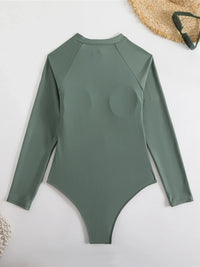 Maillot une pièce vert foncé à manches longues vu de dos à plat, col rond et coupe ajustée