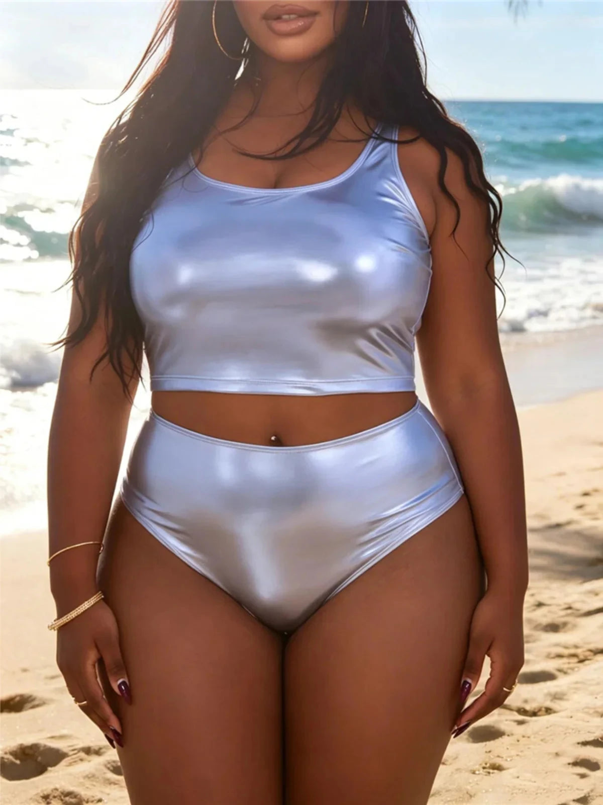 Bikini taille haute grande taille argenté métallisé porté de face sur une plage de sable par une femme, haut débardeur
