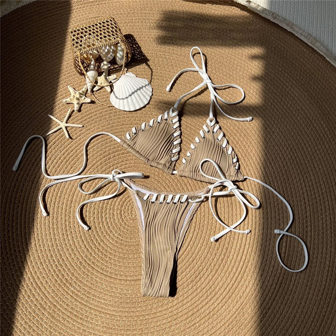 Bikini tour de cou caramel posé à plat sur une natte ronde, brides blanches longues et coquillages autour