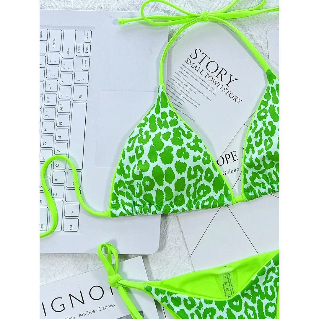 Gros plan sur le haut triangle imprimé léopard vert fluo, bordure et lacet de cou vert fluo sur des magazines