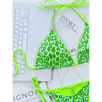 Gros plan sur le haut triangle imprimé léopard vert fluo, bordure et lacet de cou vert fluo sur des magazines