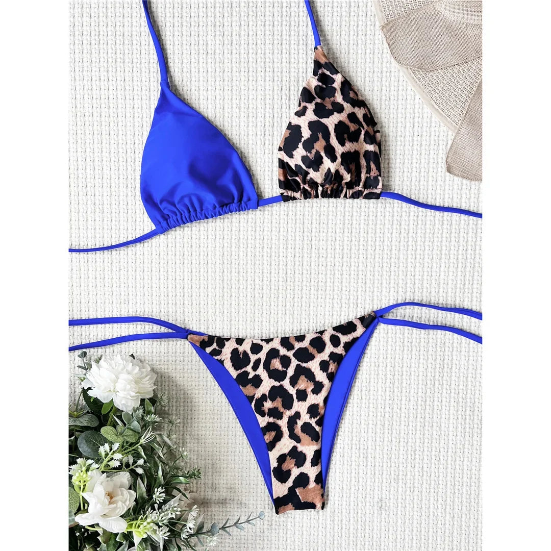 Bikini tour de cou léopard bleu roi posé à plat sur fond blanc, triangle bleu uni et bas imprimé léopard bordé de bleu