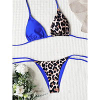 Bikini tour de cou léopard bleu roi posé à plat sur fond blanc, triangle bleu uni et bas imprimé léopard bordé de bleu