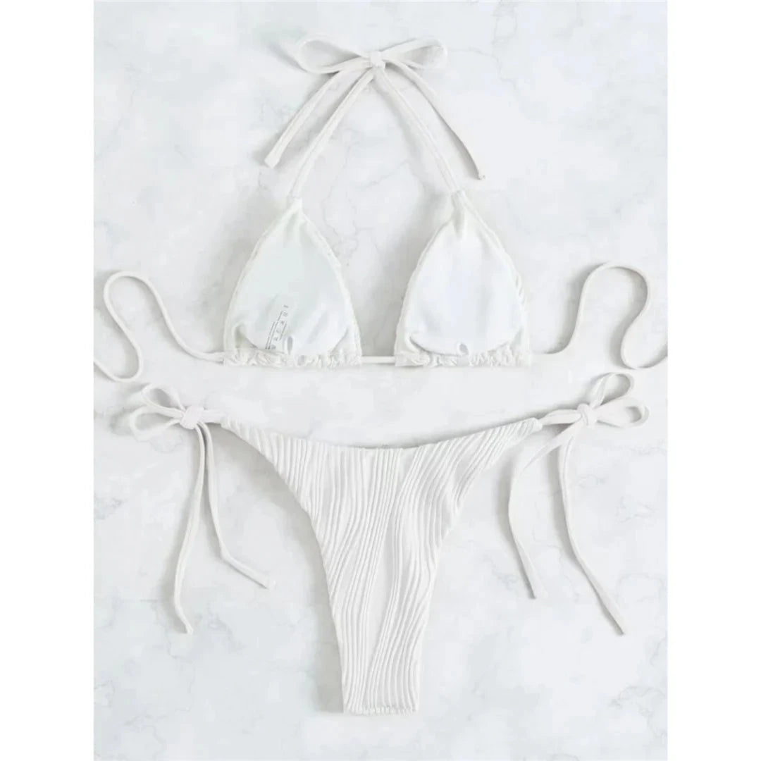 Bikini brésilien tour de cou froncé texturé blanc à plat sur du marbre blanc, lacets latéraux longs