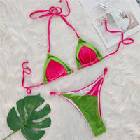 Bikini triangle en velours rose et vert posé à plat sur une fourrure blanche, feuille verte et magazine à côté