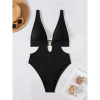 Maillot de bain une pièce décolleté plongeant noir à plat sur fond clair, avec lunettes et chapeau de paille
