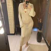 Tunique de plage crochet manches longues beige portée en longueur maxi par une femme, jambes nues sur le sol