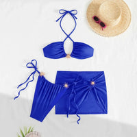 Maillot de bain trois pièces jupe halter à brides bleu étalé à plat avec chapeau de paille et lunettes de soleil dans le cadre