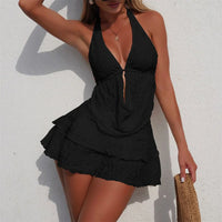 Maillot de bain trois pièces tankini avec jupe texturé noir porté de face par une femme contre un mur blanc, col halter
