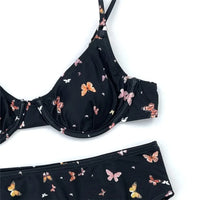 Gros plan sur les armatures et les papillons colorés du bikini taille haute noir
