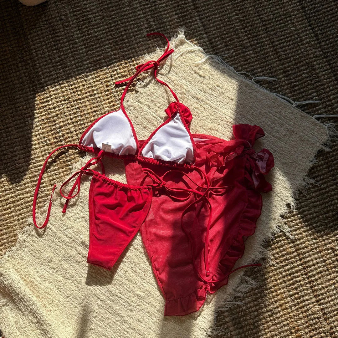 Maillot rouge à plat vu de l'intérieur, doublure blanche visible sur le haut et pareo volanté posé dessus
