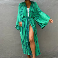 Tunique de plage imprimée manches longues à ceinture vert portée de face, bras tendu et maillot blanc dessous