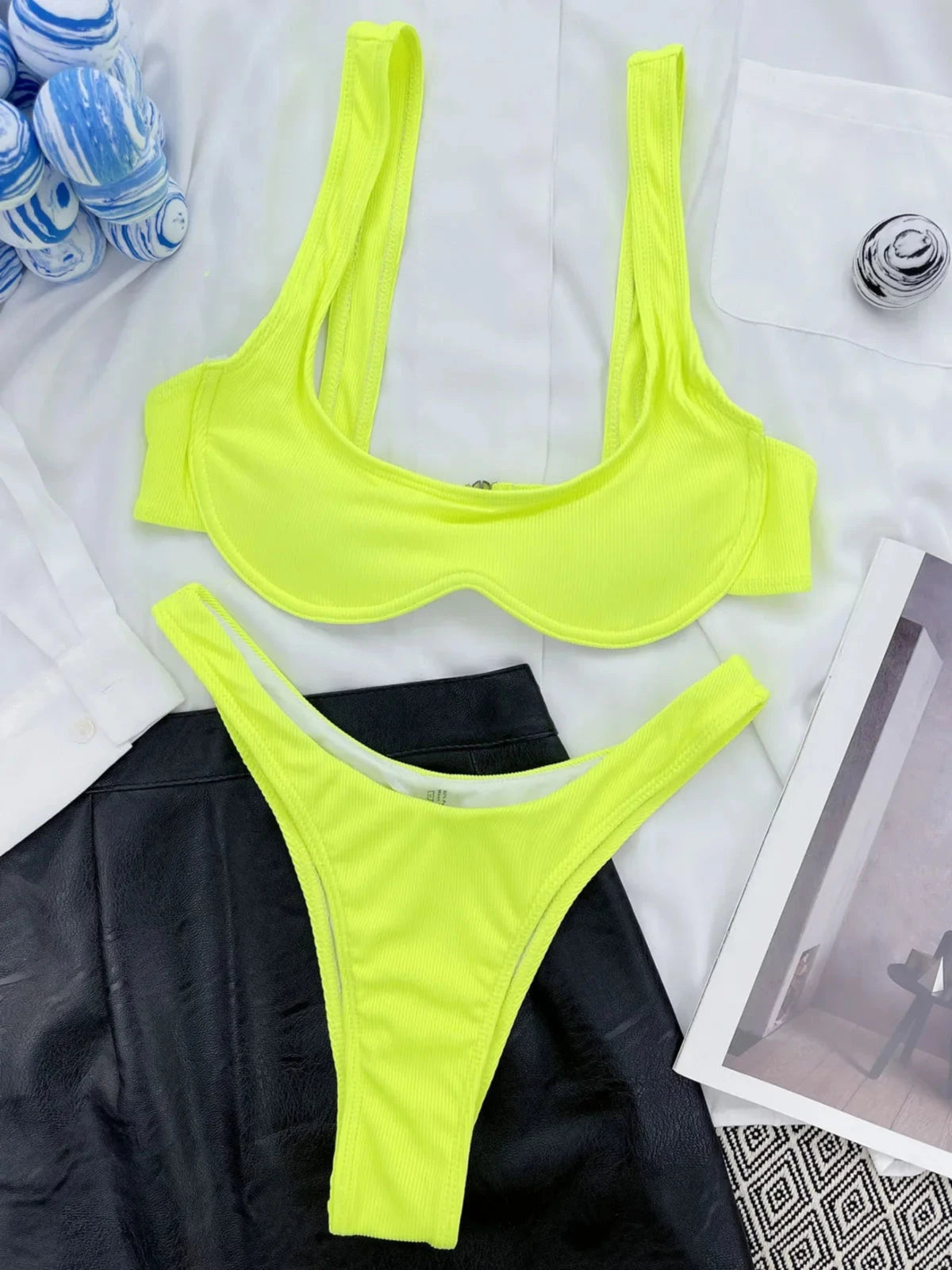 Bikini à armatures brésilien détail en V vert fluo à plat avec bouteilles et magazine, bretelles larges