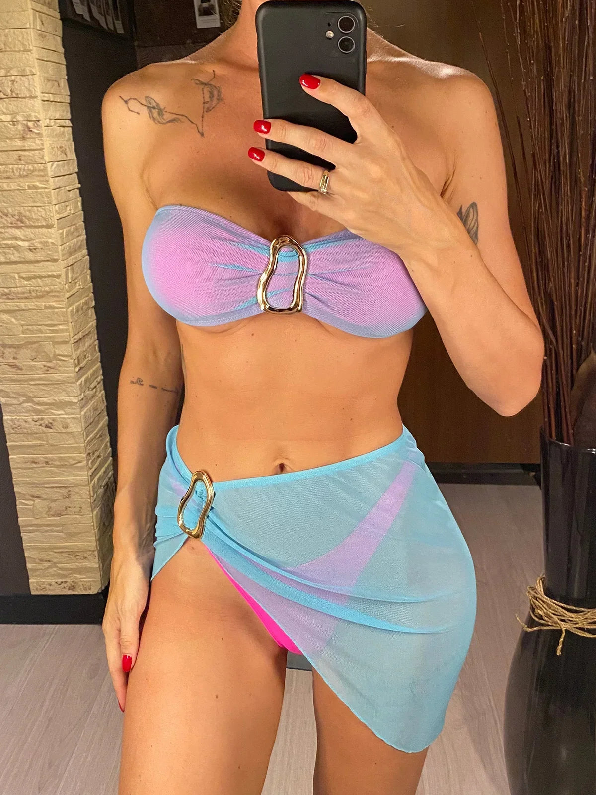 Maillot de bain trois pièces bandeau avec jupe bleu lagon et rose porté de face par une femme, boucle dorée au centre