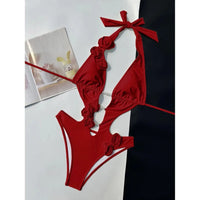 Maillot de bain une pièce décolleté V fleurs 3D rouge posé à plat, fleurs en relief sur les côtés et bretelles nouées