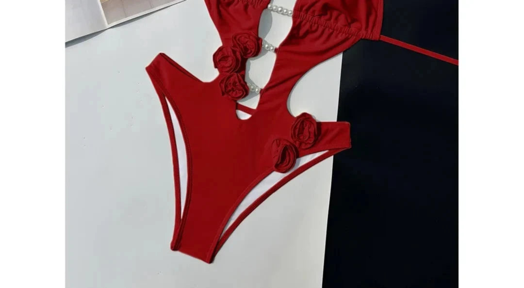 Gros plan sur le bas du maillot une pièce décolleté plongeant fleurs 3D rouge
