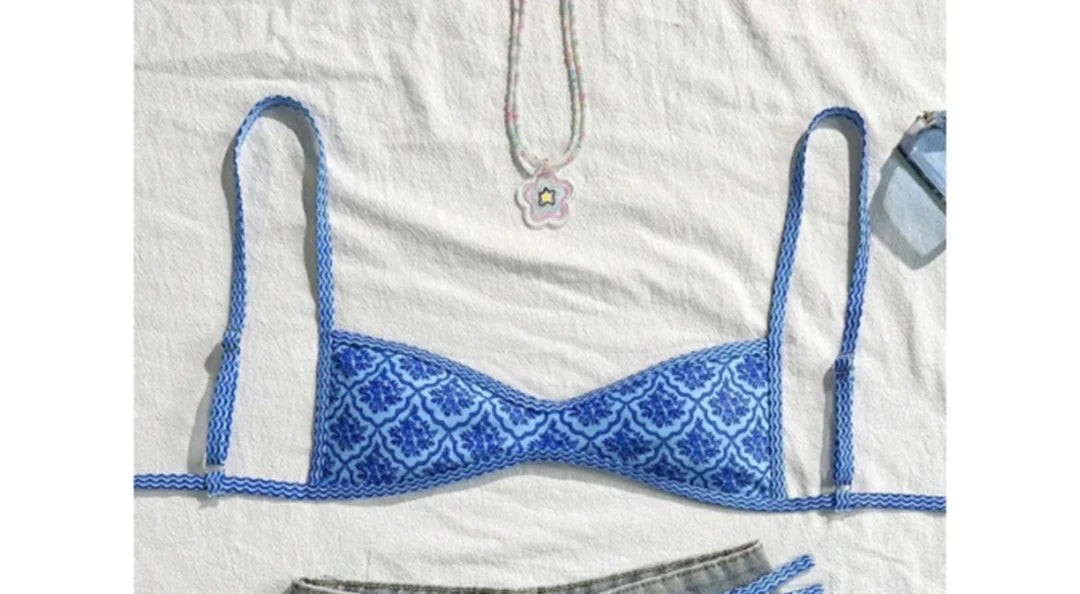 Gros plan sur le haut du bikini à bretelles fines échancré imprimé géométrique bleu