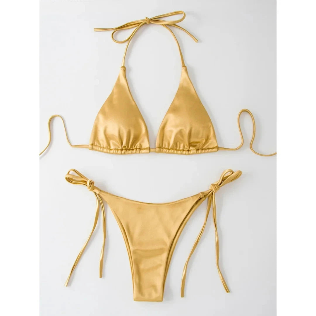 Bikini brésilien satiné triangle tour de cou doré posé à plat sur fond blanc, liens latéraux longs